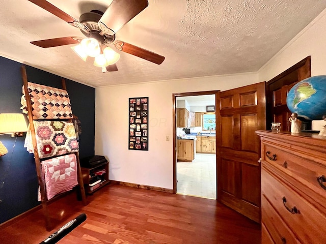 interior space featuring hardwood / wood-style flooring, ceiling fan, crown molding, and a textured ceiling