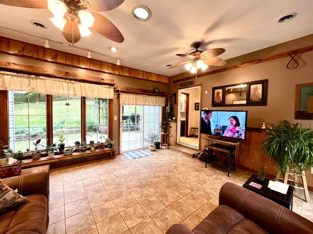 living room featuring ceiling fan and wood walls