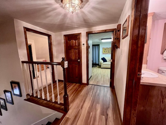 hallway with light hardwood / wood-style flooring and sink