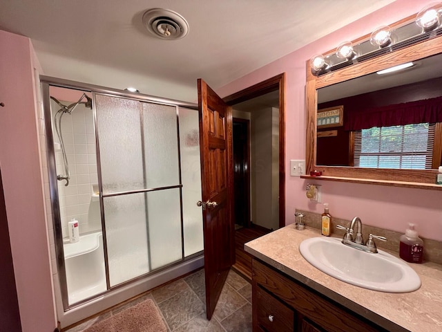 bathroom featuring vanity and a shower with shower door