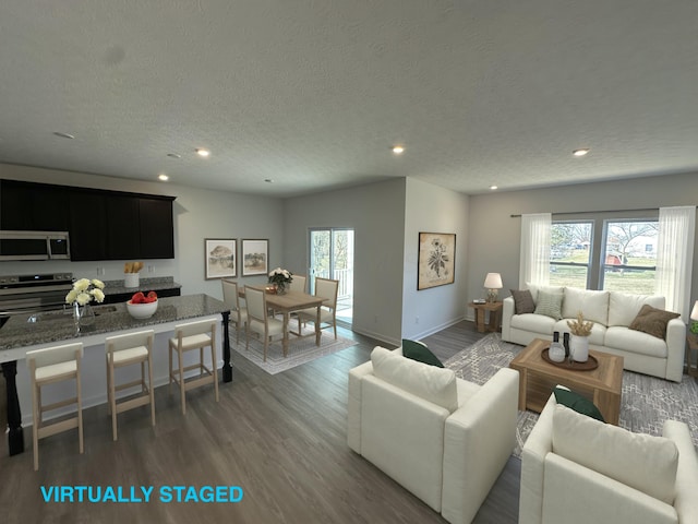 living room with recessed lighting, a textured ceiling, a healthy amount of sunlight, and wood finished floors
