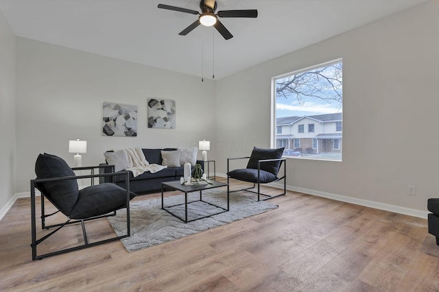 living room with light hardwood / wood-style flooring and ceiling fan