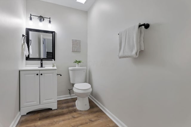 bathroom featuring hardwood / wood-style flooring, vanity, and toilet