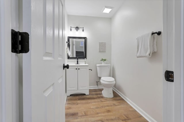 bathroom featuring wood-type flooring, vanity, and toilet