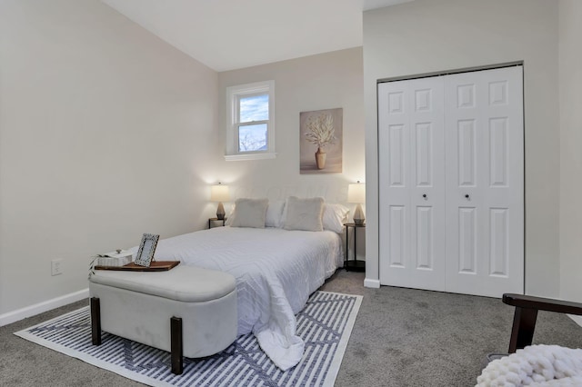 bedroom featuring dark colored carpet, vaulted ceiling, and a closet