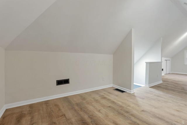 bonus room with light hardwood / wood-style flooring and vaulted ceiling