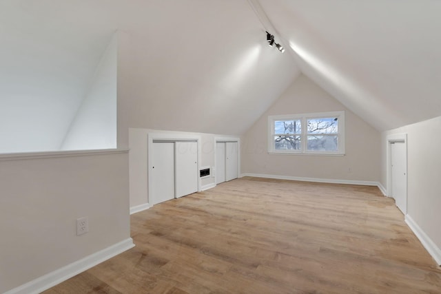 additional living space featuring lofted ceiling and light hardwood / wood-style flooring