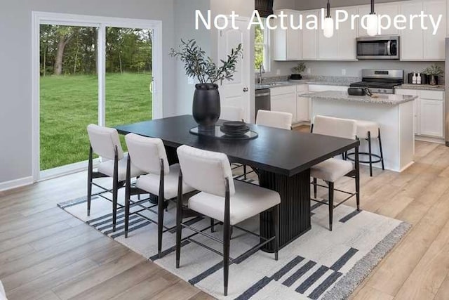 dining space featuring sink and light hardwood / wood-style flooring