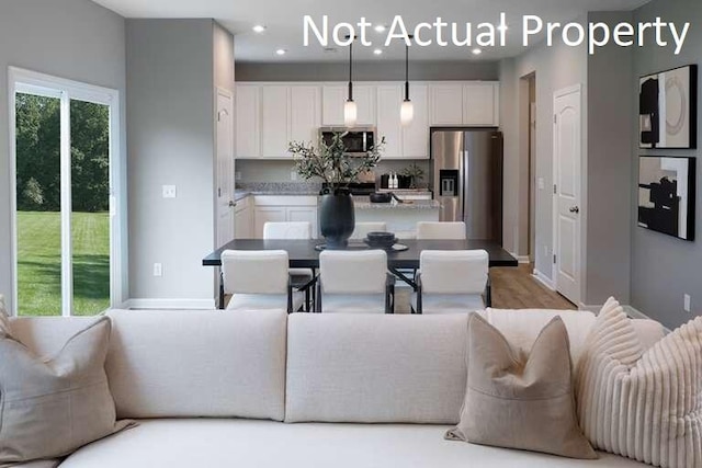 kitchen featuring white cabinetry, appliances with stainless steel finishes, and a wealth of natural light