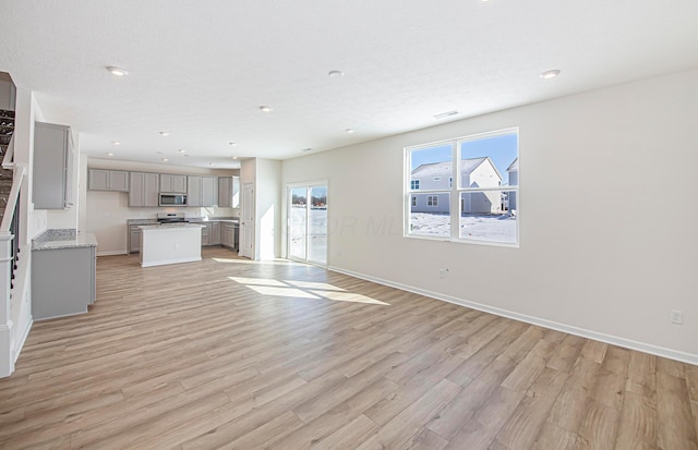 unfurnished living room with light hardwood / wood-style floors and a textured ceiling