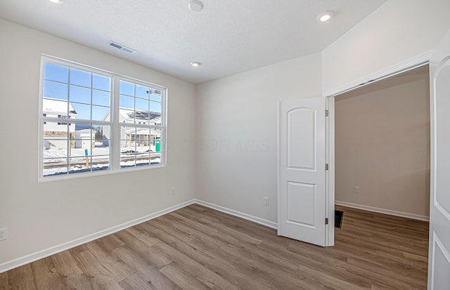 empty room featuring hardwood / wood-style floors and a textured ceiling