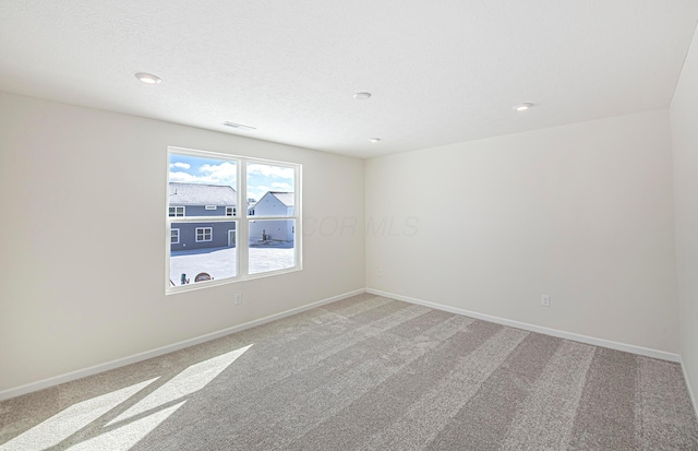 empty room featuring carpet and a textured ceiling