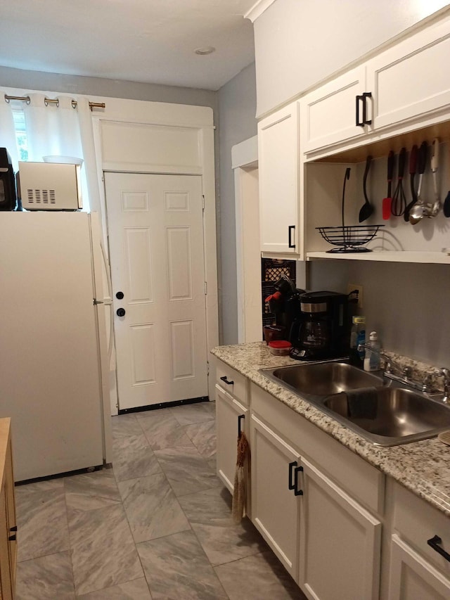 341 E 18th Ave, Columbus, OH 43201 - kitchen featuring freestanding refrigerator and white cabinetry