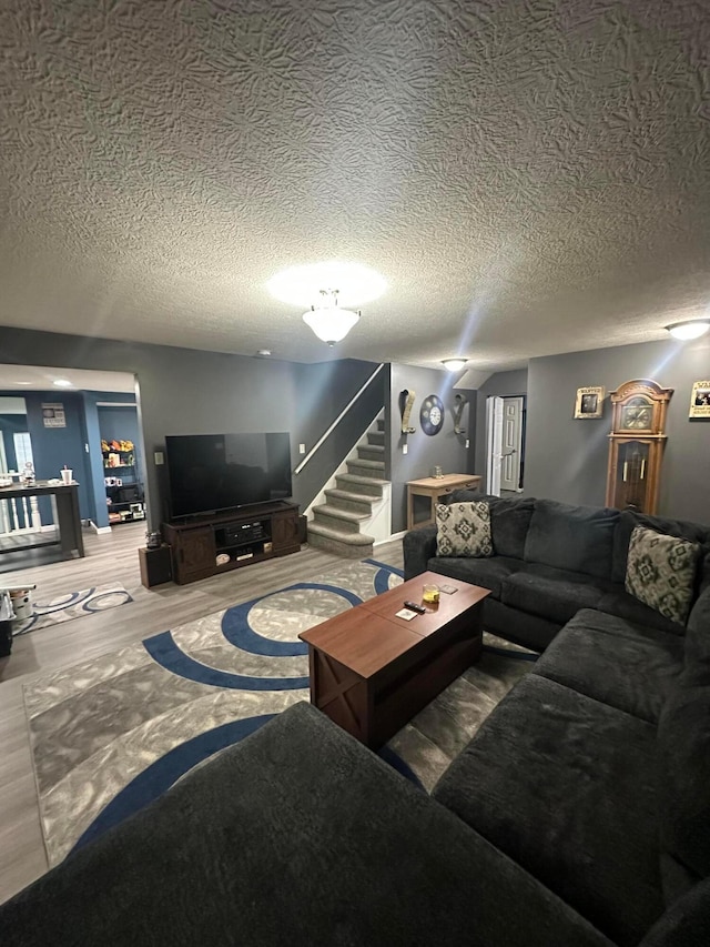 living room with wood-type flooring and a textured ceiling