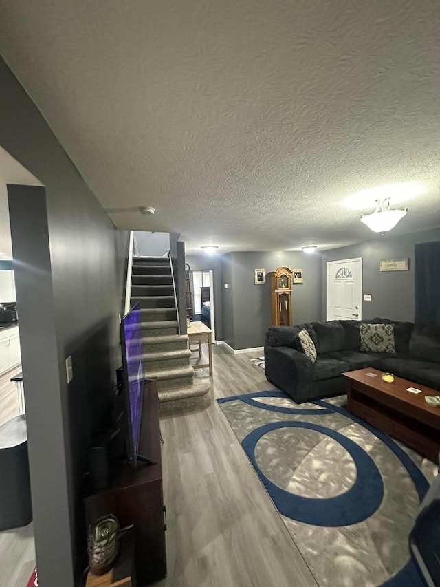 living room with a textured ceiling and light hardwood / wood-style flooring