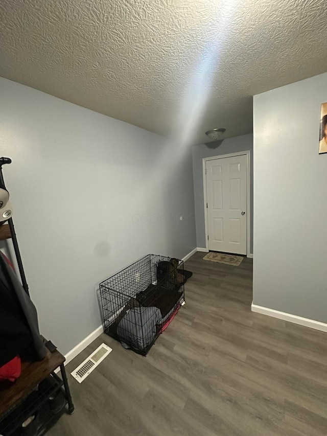 interior space with dark hardwood / wood-style flooring and a textured ceiling