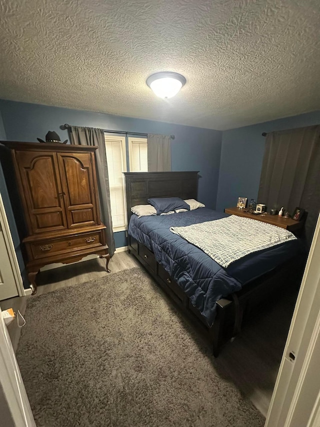 bedroom with light colored carpet and a textured ceiling