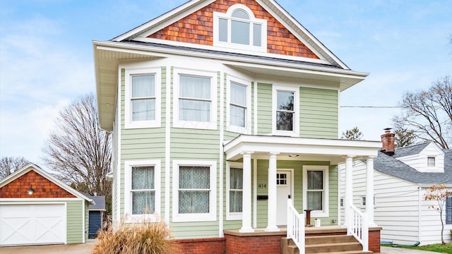 view of front of home featuring covered porch, a garage, and an outdoor structure