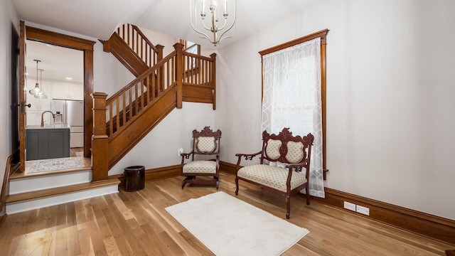 interior space featuring sink, light hardwood / wood-style floors, and a notable chandelier