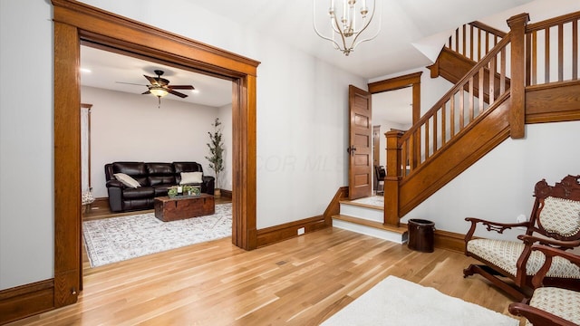 entrance foyer featuring ceiling fan with notable chandelier and light hardwood / wood-style floors