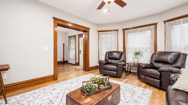 living room featuring ceiling fan, light hardwood / wood-style flooring, and a healthy amount of sunlight