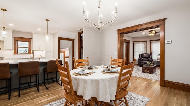 dining space featuring ceiling fan with notable chandelier, light wood-type flooring, and a wealth of natural light