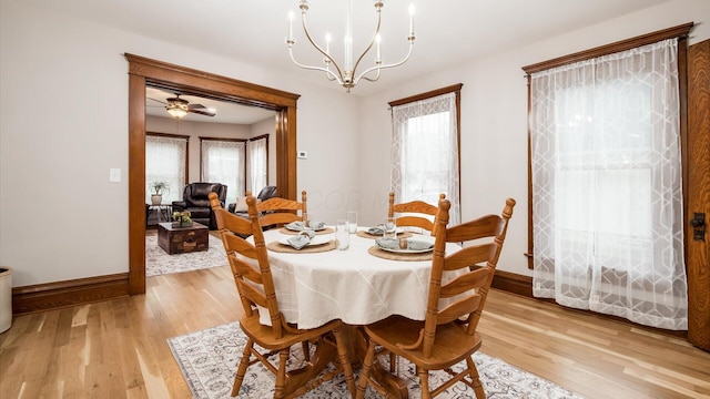 dining space featuring ceiling fan with notable chandelier, light wood-type flooring, and a wealth of natural light