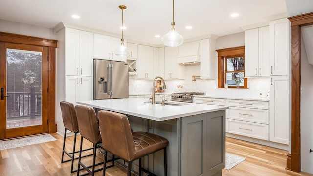 kitchen featuring white cabinets, light wood-type flooring, and high end appliances