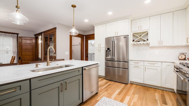 kitchen featuring white cabinets, hanging light fixtures, high quality appliances, and sink