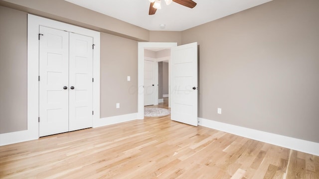 unfurnished bedroom featuring a closet, light hardwood / wood-style floors, and ceiling fan