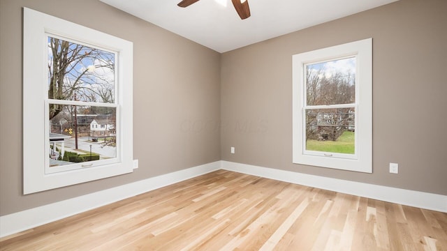 spare room featuring hardwood / wood-style flooring, plenty of natural light, and ceiling fan