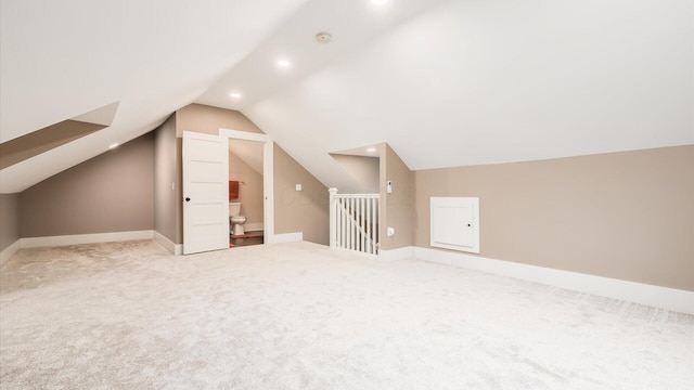 bonus room with carpet flooring and vaulted ceiling