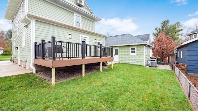 rear view of property featuring a yard, central air condition unit, and a wooden deck