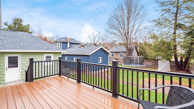 deck featuring a lawn and a trampoline