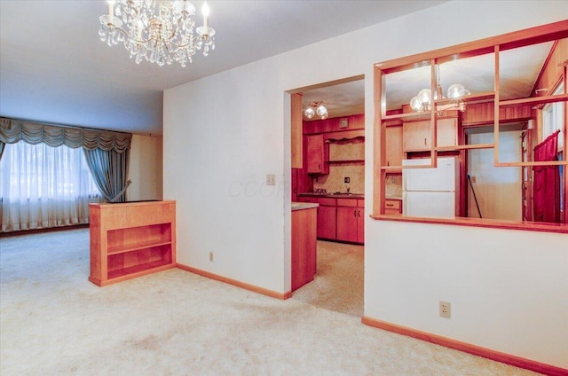 interior space with decorative light fixtures, white refrigerator, light carpet, and a chandelier