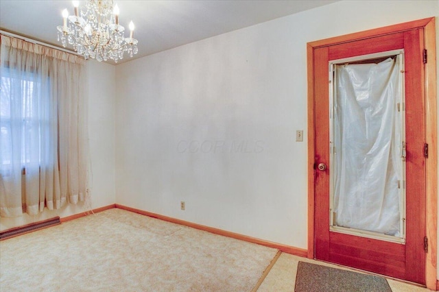 entrance foyer with carpet flooring and a chandelier