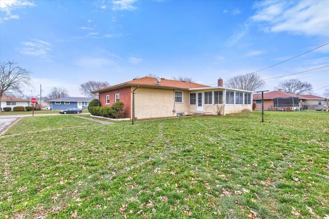 view of side of home featuring a yard and a sunroom