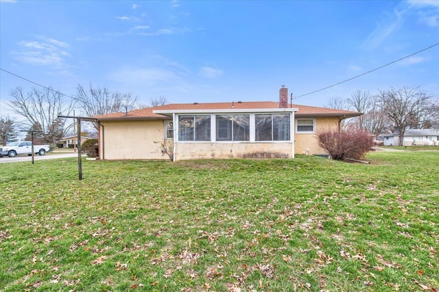 back of property featuring a sunroom and a yard