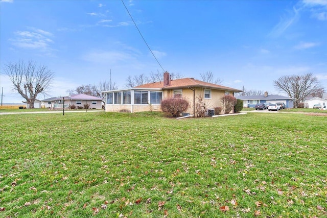 exterior space with a sunroom and a front yard