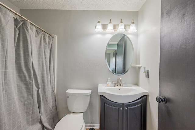 bathroom with vanity, toilet, a textured ceiling, and walk in shower