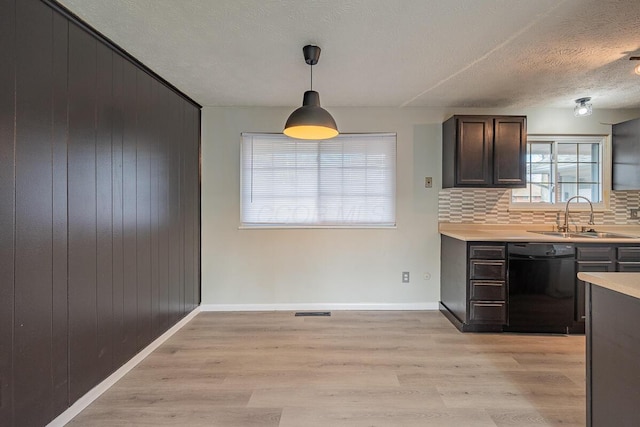 kitchen featuring dishwasher, sink, decorative backsplash, a textured ceiling, and decorative light fixtures