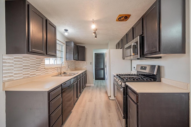 kitchen featuring dark brown cabinets, sink, a textured ceiling, and appliances with stainless steel finishes