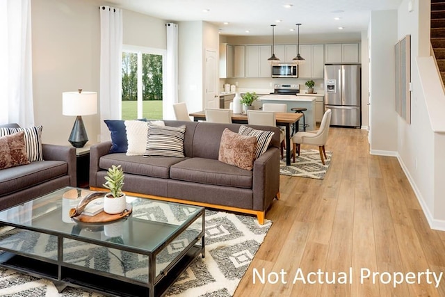 living room featuring stairway, recessed lighting, light wood-style flooring, and baseboards