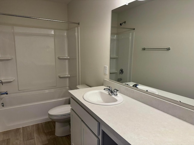 bathroom featuring toilet, shower / bath combination, wood finished floors, and vanity