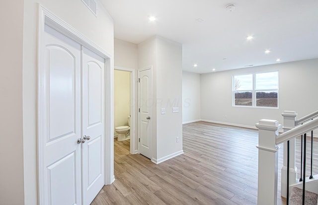 hallway with visible vents, baseboards, light wood-style flooring, stairs, and recessed lighting