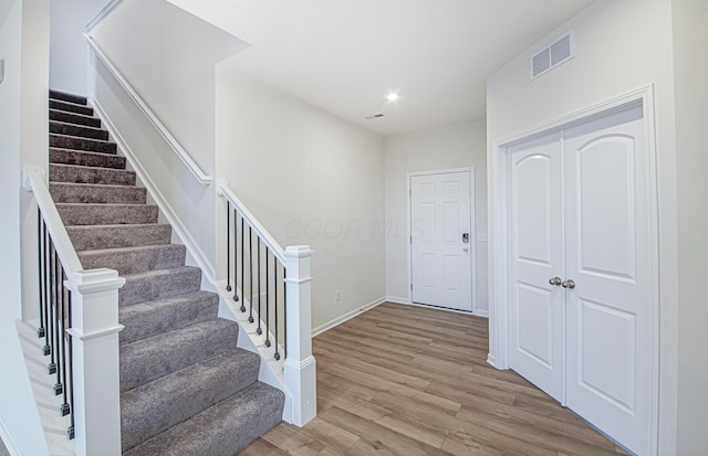 entryway featuring recessed lighting, visible vents, stairway, wood finished floors, and baseboards