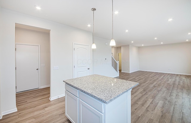 kitchen featuring baseboards, light wood-style flooring, decorative light fixtures, a center island, and recessed lighting