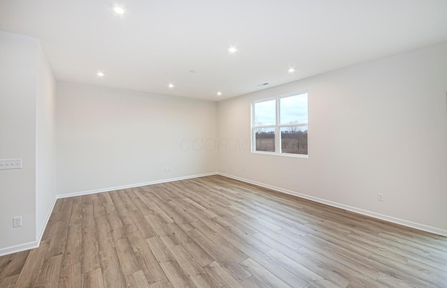 empty room with baseboards, recessed lighting, and light wood-style floors