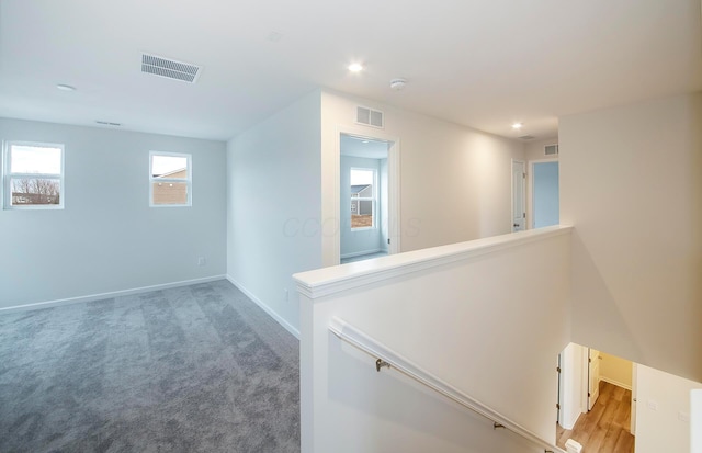 corridor featuring recessed lighting, an upstairs landing, visible vents, and baseboards