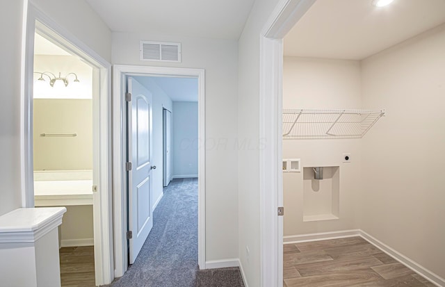 laundry room with visible vents, electric dryer hookup, wood finished floors, laundry area, and baseboards